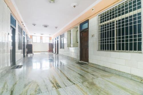 阿里格尔SPOT ON Hotel Anand Bhawan的学校大楼的空走廊,铺有木地板
