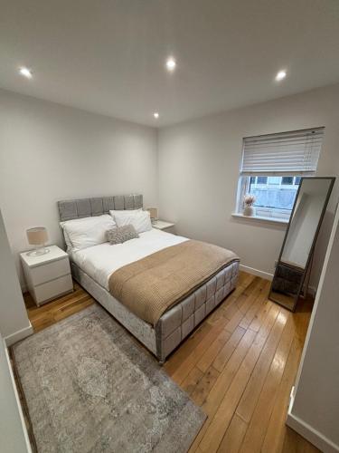 因弗内斯Gateway Apartment的一间卧室设有一张大床和一个窗户。