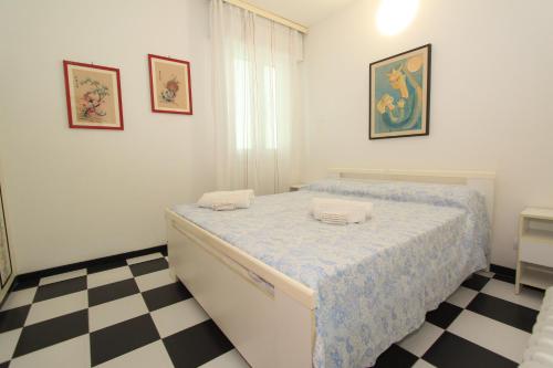 利多波波萨Eco del Mare Apartments的一间卧室配有一张床,铺有一个 ⁇ 板地板