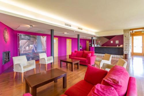 索斯-德尔雷卡托利科Hotel Alda Triskel的客厅配有粉色家具和桌子