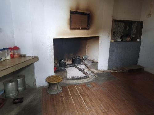 KohīmaAvi Homestay的一间带壁炉、锅和平底锅的房间