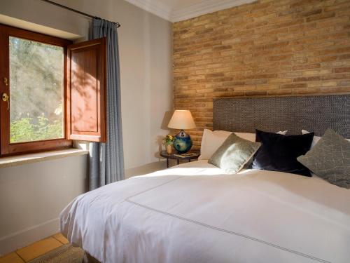 Fuentespalda拉托威斯克瑞莱沙陀旅馆的卧室配有白色的床和砖墙
