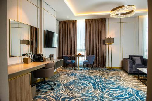 巴库InterContinental Baku, an IHG Hotel的酒店客房带大堂,带桌子和椅子。