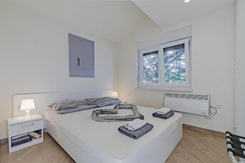 波斯蒂拉Apartment Vila Inga的白色的卧室设有床和窗户