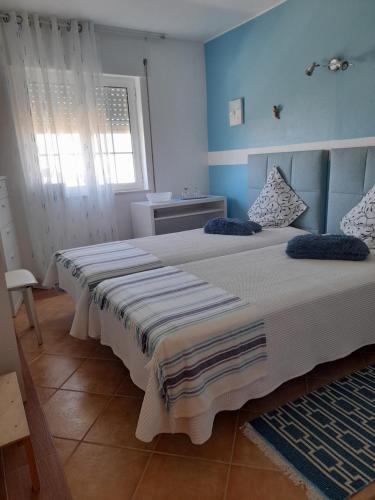 萨格里什Casa Da Anita的一间卧室设有两张带蓝色墙壁的床