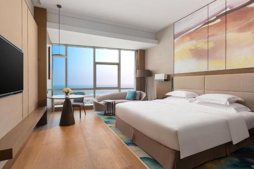 北海北海银滩皇冠假日酒店的酒店客房设有一张大床和一张沙发。