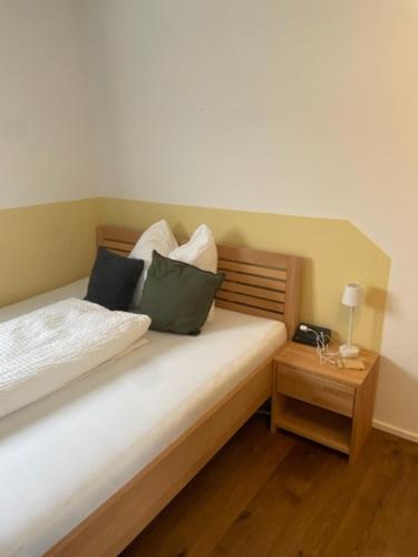 Pinsdorf1 Zimmer Appartement nahe Gmunden Top2的一间卧室配有带枕头的床铺和床头柜