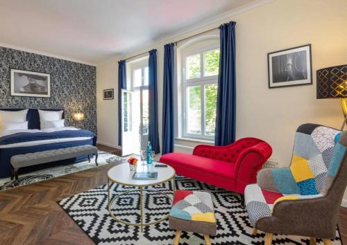 赖因斯贝格Schlosshotel Rheinsberg的客厅配有床和红色椅子