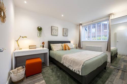 曼彻斯特Spacious & Modern 4-Bedroom Townhouse的一间卧室配有一张床、一张书桌和一个窗户。