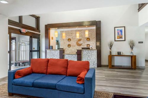 休斯顿康福特茵酒店套房酒店FM1960 - 冠军酒店的客厅配有蓝色长沙发及橙色枕头