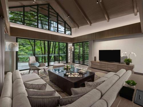 茂物Pullman Ciawi Vimala Hills Resort的客厅设有大沙发和电视
