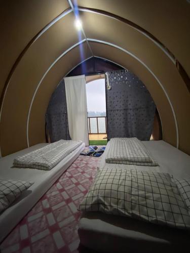 PalayanganPandawa camp的卧室配有拱形床和窗户