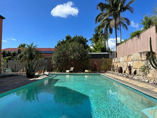 黄金海岸Relaxing Burleigh Heads Home with Swimming Pool的庭院里的一个蓝色海水游泳池