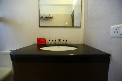钦奈OYO NIMALAN RESIDENCY的浴室设有黑色水槽和镜子