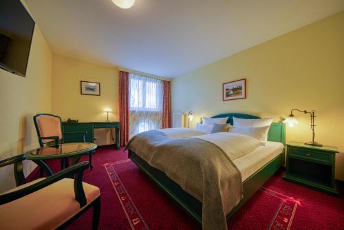 维斯马Hotel Seeblick Wismar的酒店客房带一张大床和一把椅子
