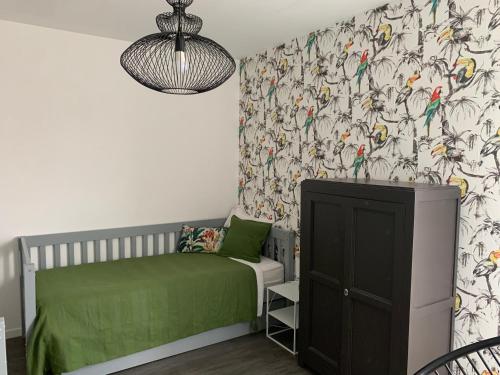 里尔Place verte 2302的儿童卧室配有绿色的床和鸟壁纸