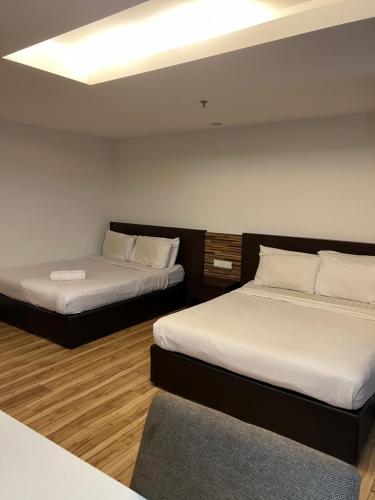 哥打巴鲁哥打巴鲁城特色公寓的一间设有两张床和一张沙发的房间