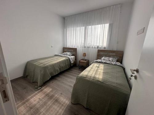 拉纳卡Cozy 3 Bedroom Apartment 300M from the SEA的小型客房 - 带2张床和窗户