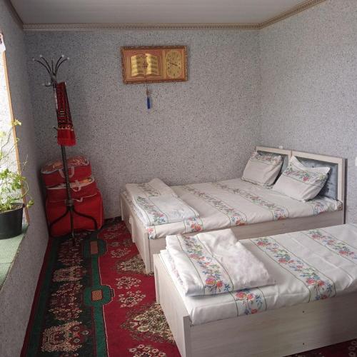 Barlos Oromgohi的一间设有两张床和红地毯的客房