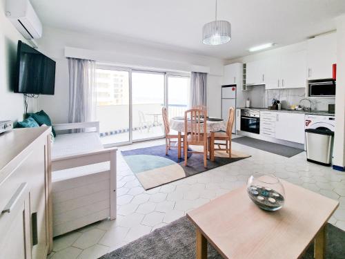 波尔蒂芒Apartment Concorde Sky Vista Mar的厨房以及带桌椅的起居室。