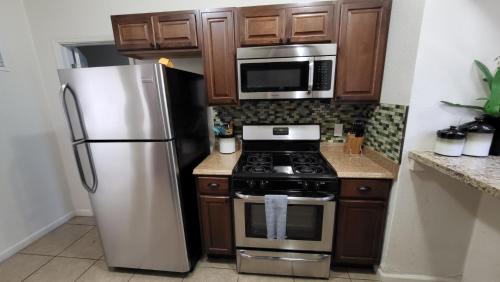 凤凰城U1 - Entire 2 BR Pet Friendly APT in DT PHX with pkg的厨房配有不锈钢冰箱和微波炉。