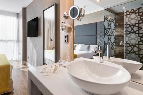 塞维利亚加泰罗尼亚吉拉达酒店的一间带水槽和大镜子的浴室