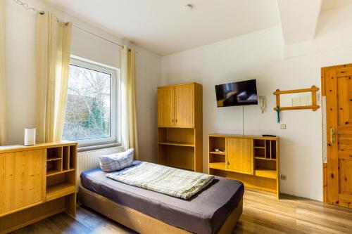 开姆尼茨Apartmenthaus in Chemnitz für Monteure的一间卧室设有一张床、木制橱柜和窗户。