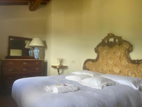 Badia A PassignanoIl Fiorino di Badia的卧室配有白色的床和2条毛巾