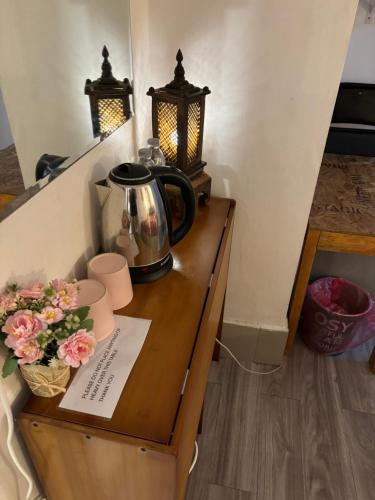 曼谷拉罗坎达酒店的木桌上的茶壶,上面有鲜花