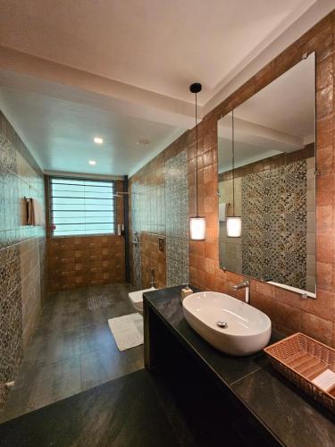 卡尔贾特River Estates Luxury Resort & Spa的一间带水槽和大镜子的浴室