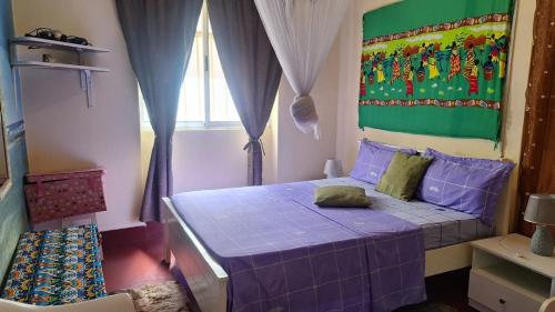 塔拉法尔Casa de Férias的一间卧室设有紫色的床和窗户