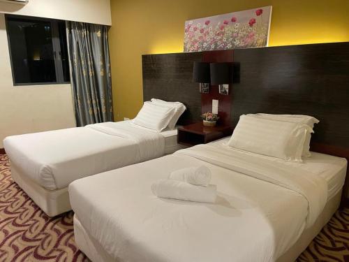 哥打京那巴鲁KK Homestay City Deluxe room - Ming Garden Hotel & Residence的酒店客房,配有两张带毛巾的床