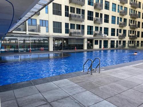 哥打京那巴鲁KK Homestay City Deluxe room - Ming Garden Hotel & Residence的大楼前的大型游泳池