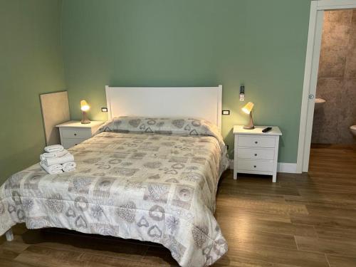 卡诺萨迪普利亚RoMa Apartment & Room的一间卧室配有一张带2个床头柜和2盏灯的床。