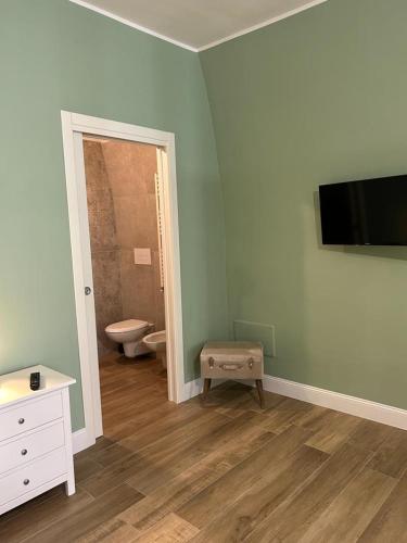 卡诺萨迪普利亚RoMa Apartment & Room的一间带卫生间的浴室和墙上的电视