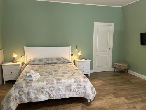 卡诺萨迪普利亚RoMa Apartment & Room的一间卧室设有一张大床和两个床头柜
