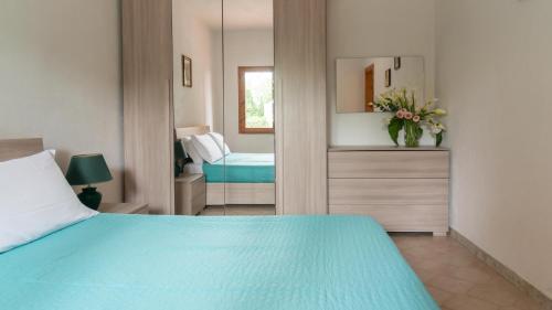 波尔托奥蒂罗卢Casa Ficus的一间卧室配有蓝色的床和镜子