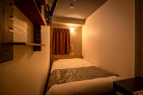 东京Hotel Peace (Adult Only)的一个小房间的小床,设有窗户