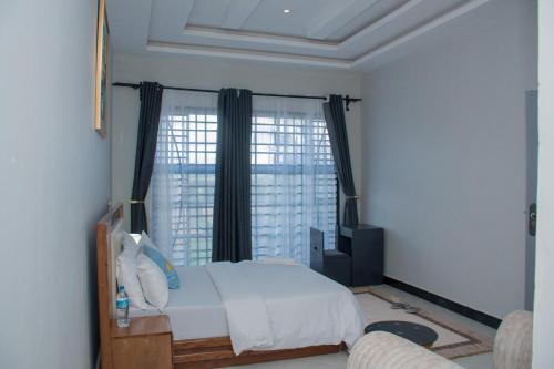 BabatiLadari Apartments的一间卧室设有一张床和一个大窗户