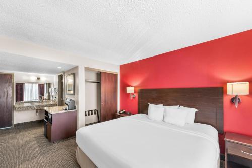 哥伦布市Quality Inn的一张位于酒店客房的大床,设有红色的墙壁