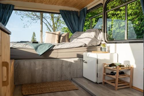 普列维扎Bus Ikarus的一间位于小房子的卧室,配有一张床和一台冰箱