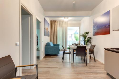 切尔维亚Elegance Suite Apartments的用餐室以及带桌椅的起居室。