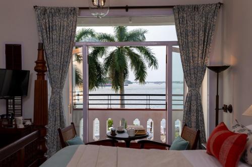 科钦Brunton Boatyard - CGH Earth的一间卧室配有一张床,享有海景