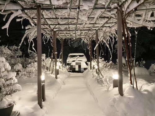 富士河口湖兰波旅馆的停在雪地覆盖的凉亭下的汽车