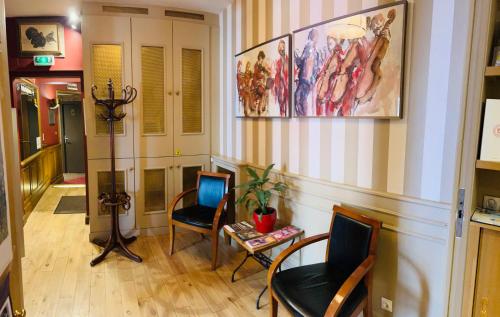 滨海图维列中央酒店的客厅配有两把椅子、一张桌子和一幅画