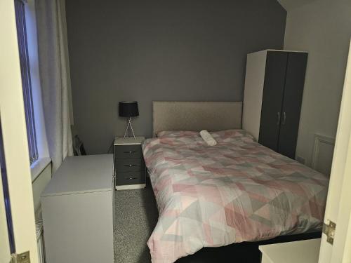 特伦特河畔斯托克Hygis Great Home of Relaxations的一间小卧室,配有床和床头柜