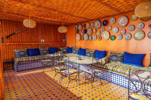 拉巴特Riad el wazzania的一间墙上配有沙发、桌子和盘子的房间