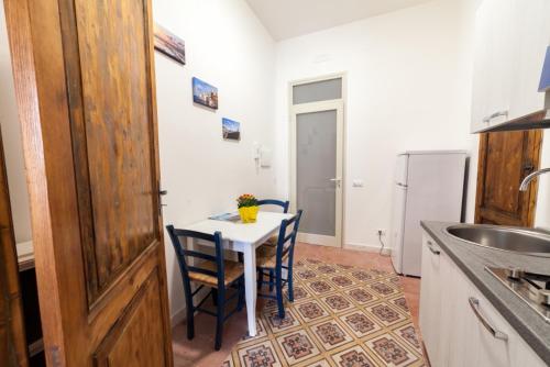 特拉帕尼伐戴拉250公寓的厨房配有桌子、两把椅子和冰箱