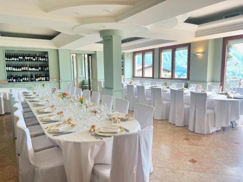 里瓦迪索尔托米兰达酒店的一个带白色桌子和白色椅子的大型宴会厅