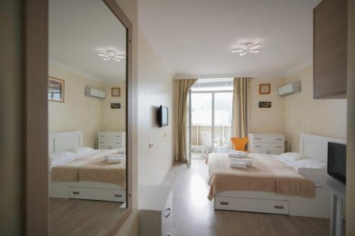 巴统奥比公寓式酒店的一间卧室配有两张床和镜子